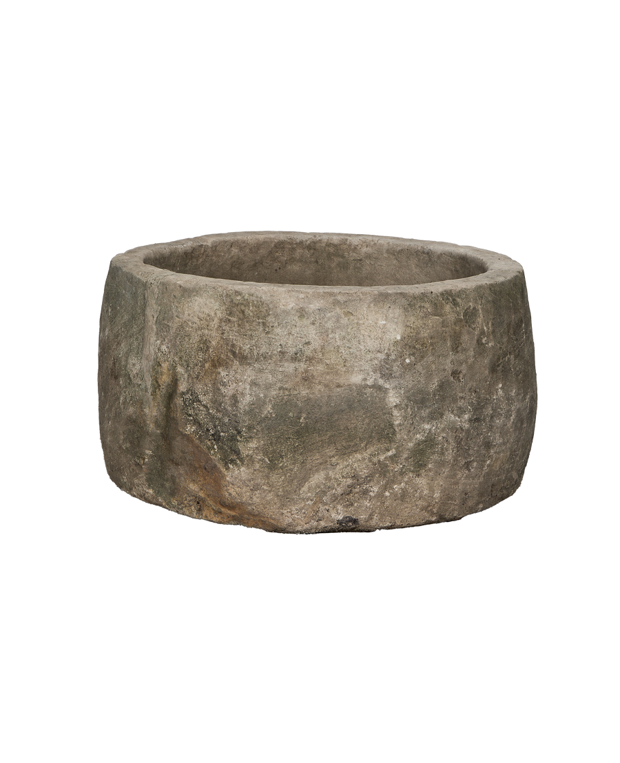 Round vintage limestone trough showcasing natural texture, minor chips, and weathered patina from a side angle.