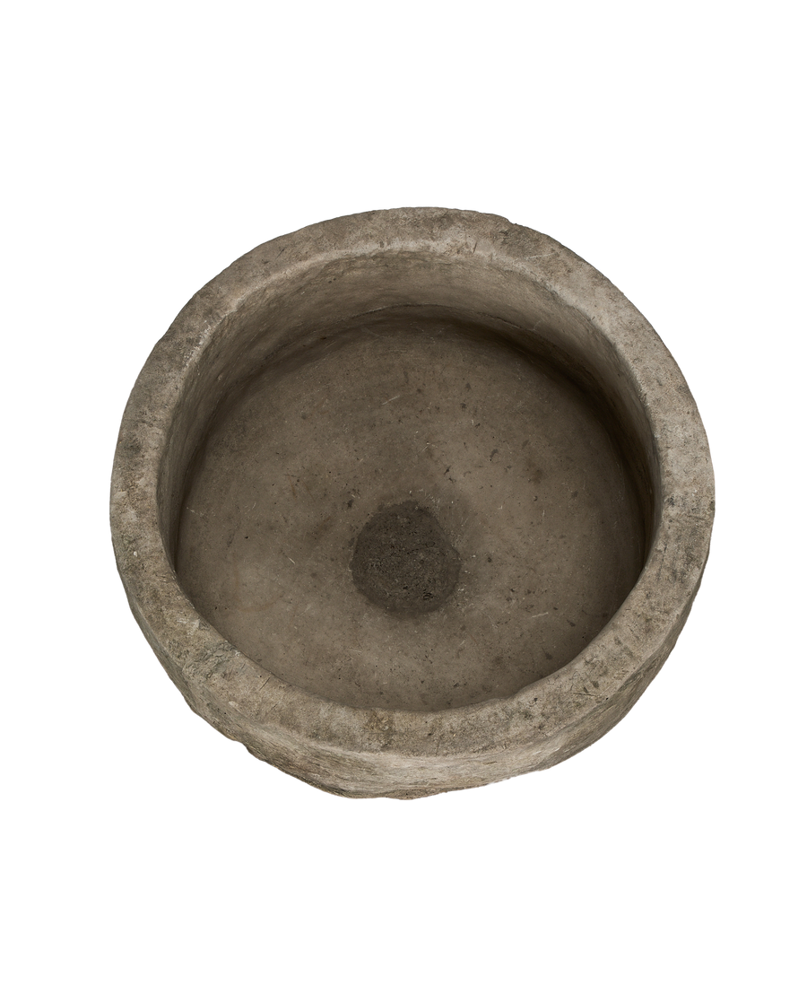 Round vintage Indonesian limestone trough, top view revealing rough interior texture and drain hole.