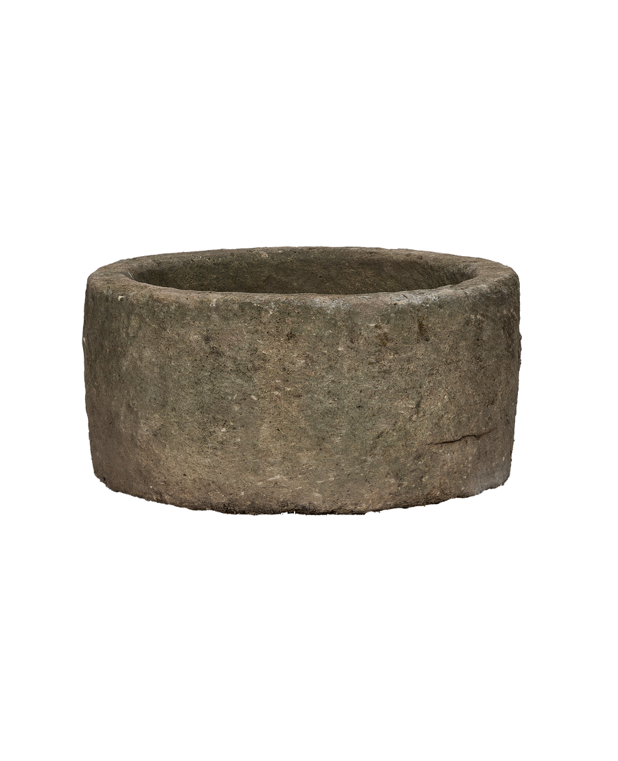 Vintage round limestone trough, aged grey texture with slight surface imperfections, Indo-inspired.