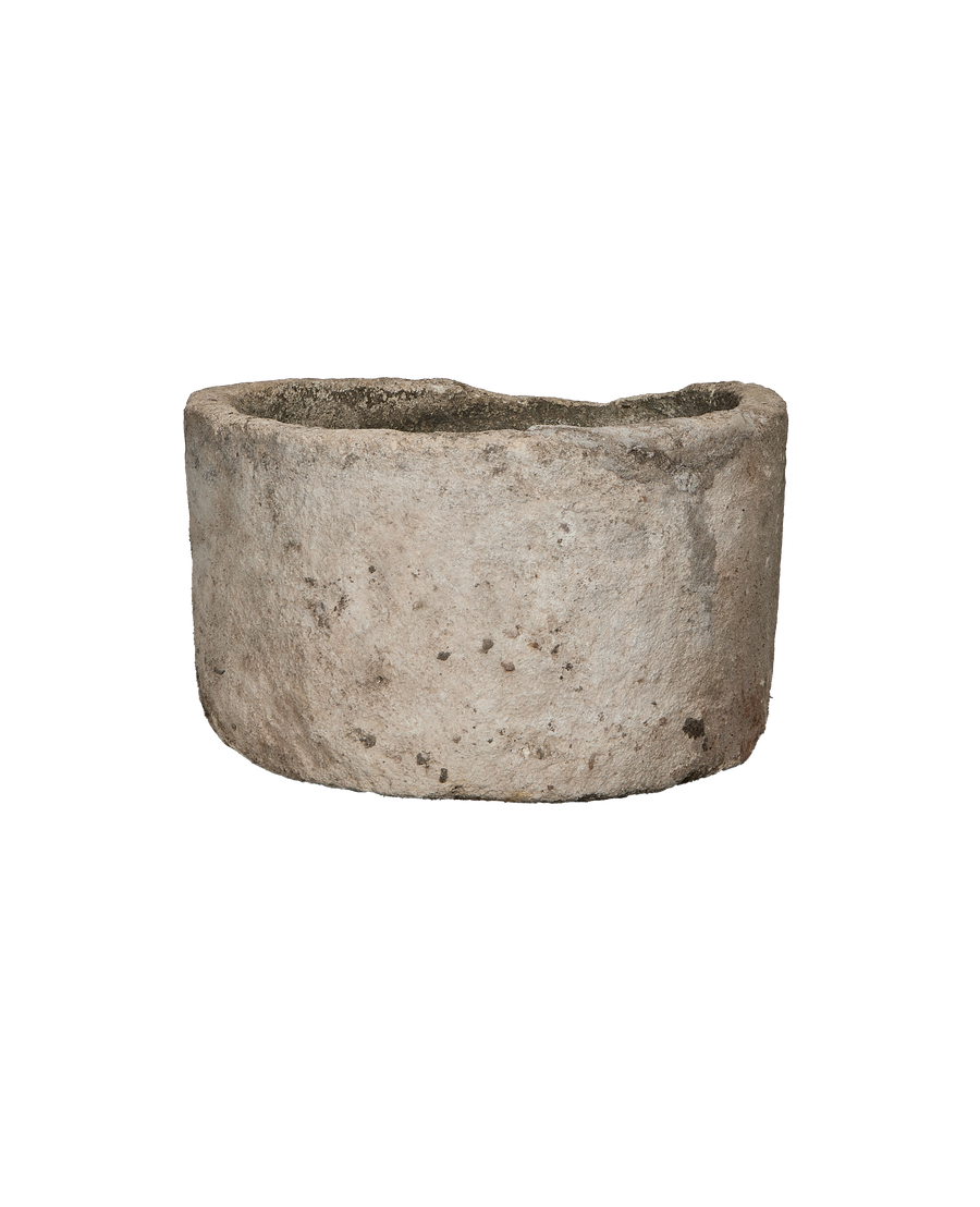 Round vintage Indonesian limestone trough showcasing weathered texture and rim detail on black.