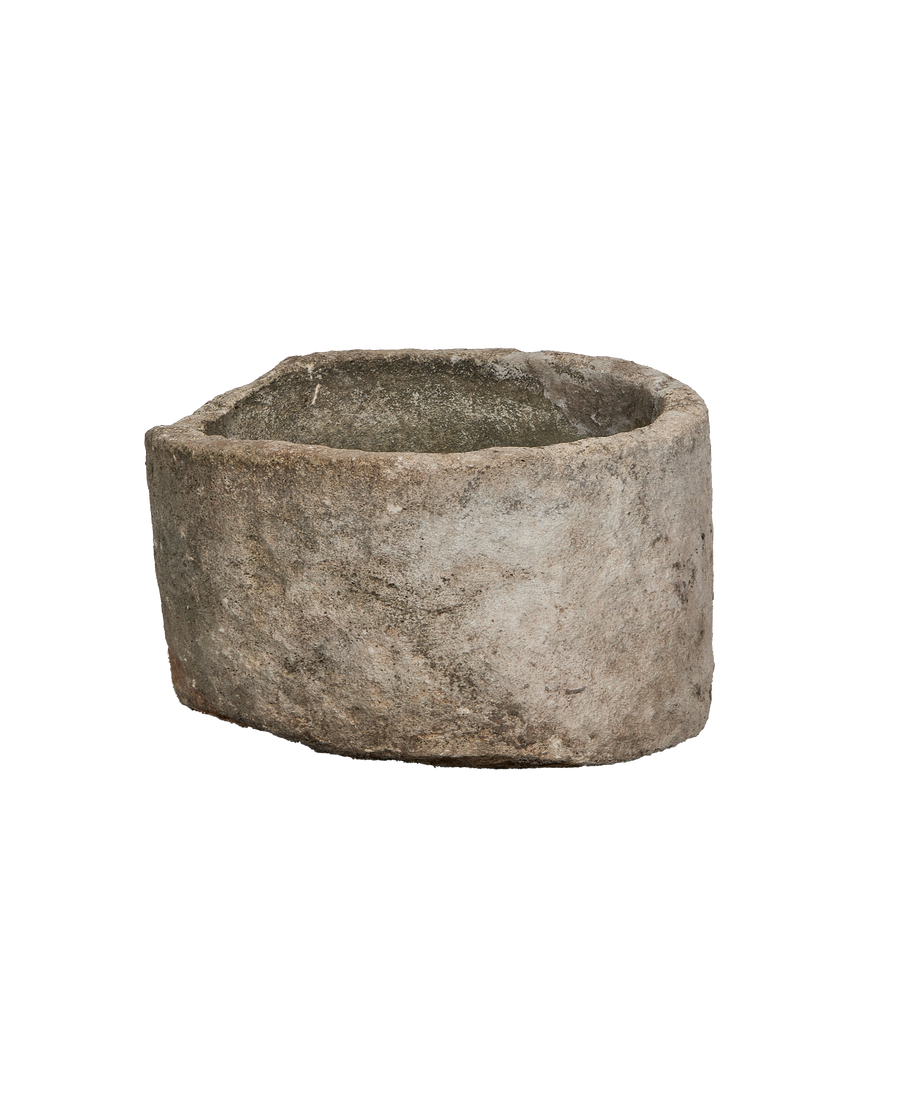 Vintage round Indonesian limestone trough, showing a slightly angled profile and aged patina.