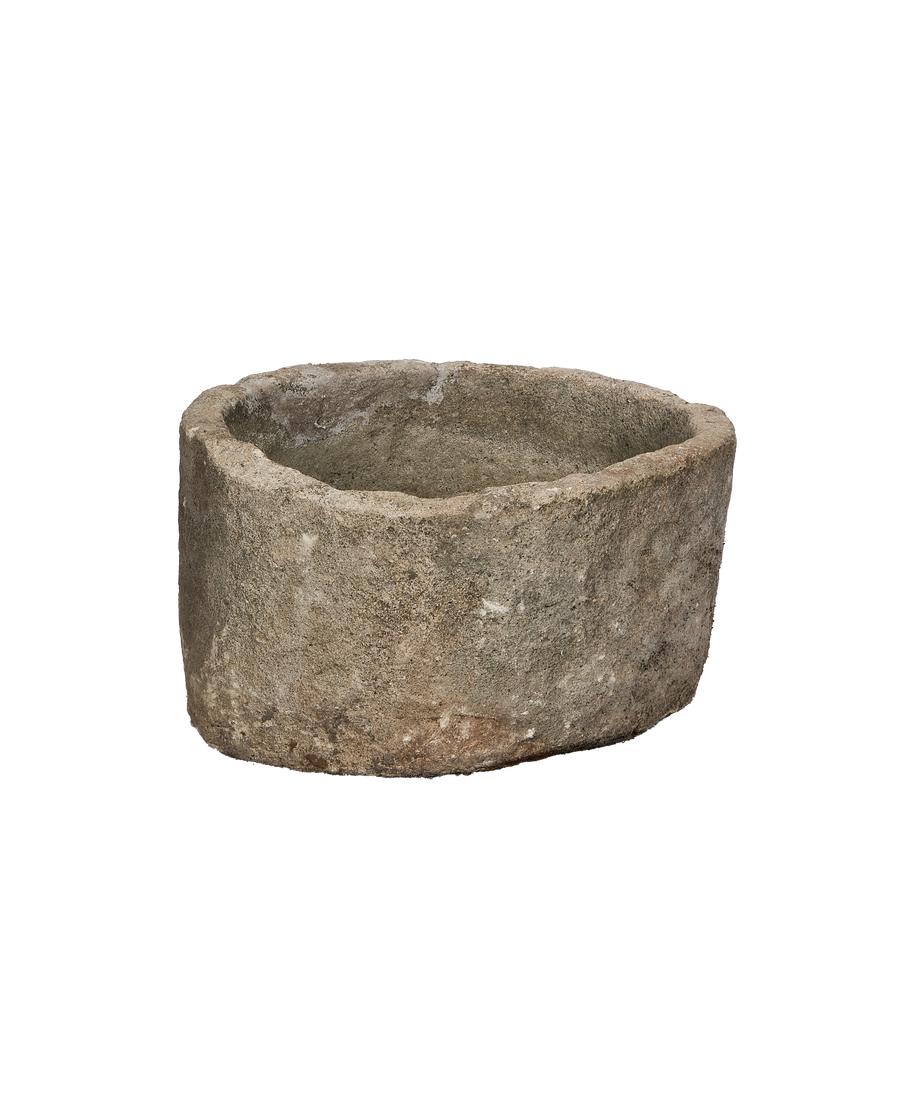 Vintage Indonesian round limestone trough, showing natural wear and rough textured exterior.