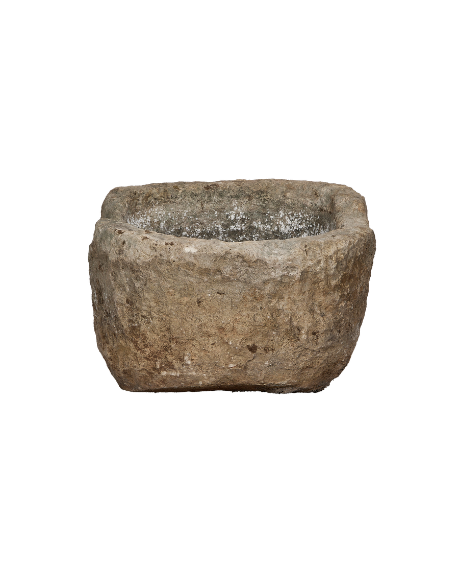 Vintage Indonesian limestone trough, showing rough exterior with white mineral deposits inside.