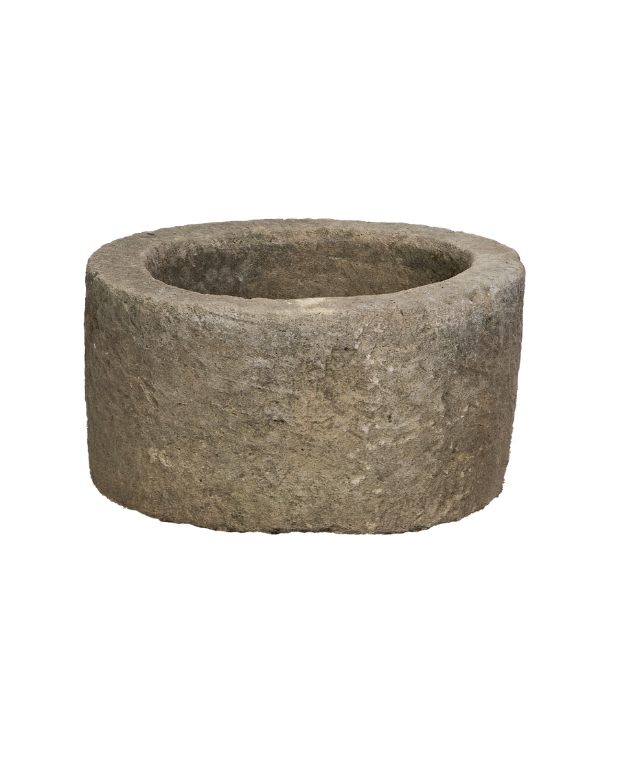Vintage Indonesian round limestone trough, showing weathered texture and interior basin detail, from left angle.