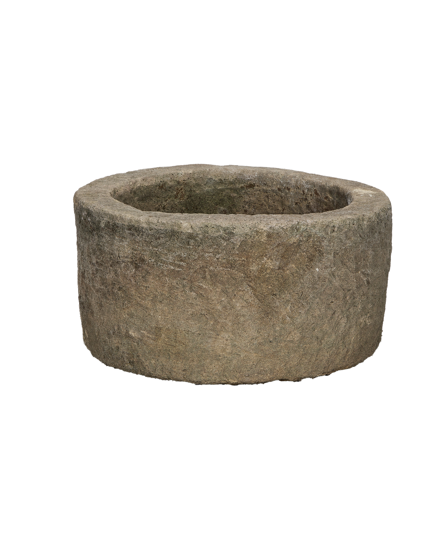 Vintage Indonesian limestone trough, round, showing texture and rim detail on black background.