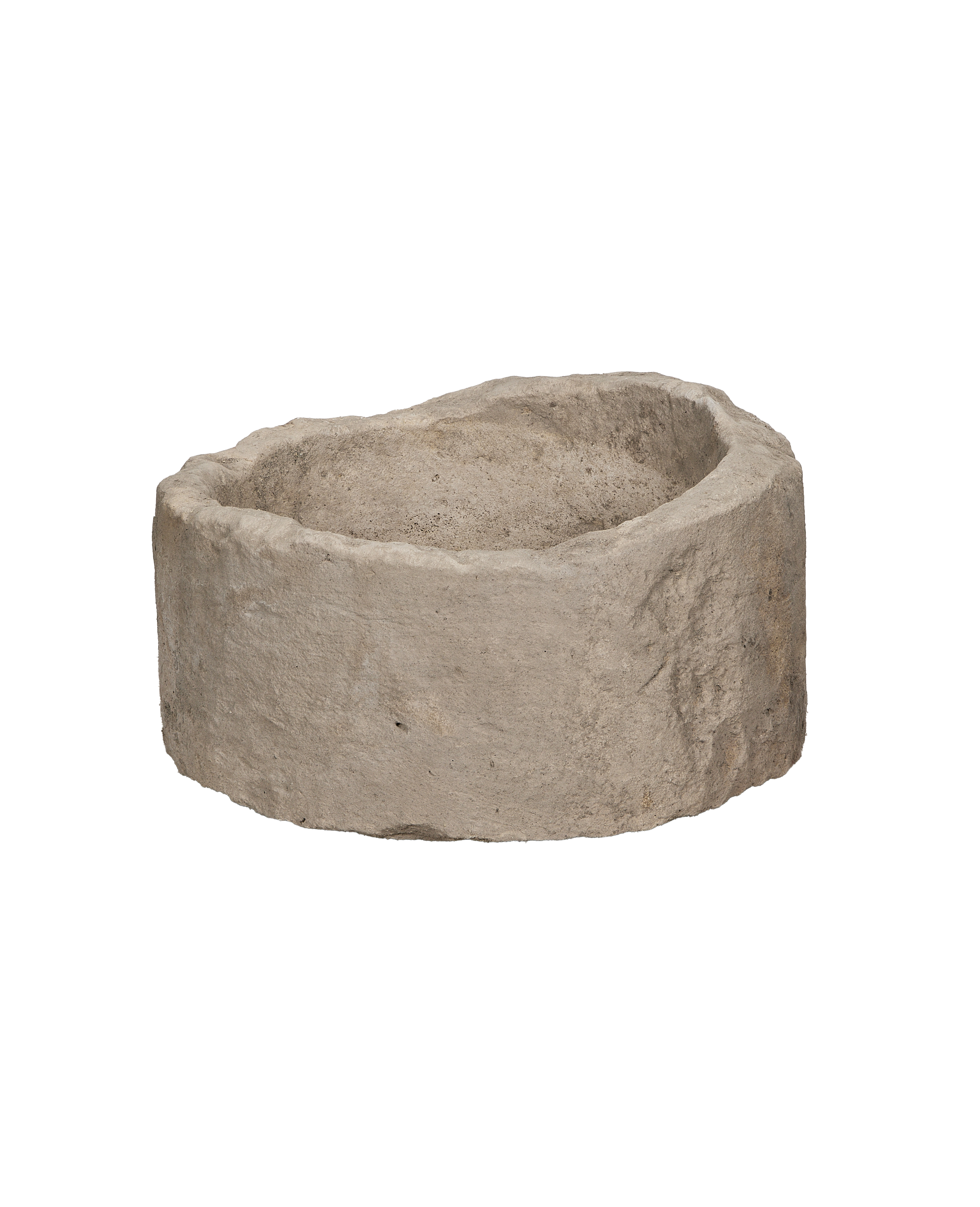 Vintage round Indonesian limestone trough, showing rough textured exterior and eroded rim from an angle.
