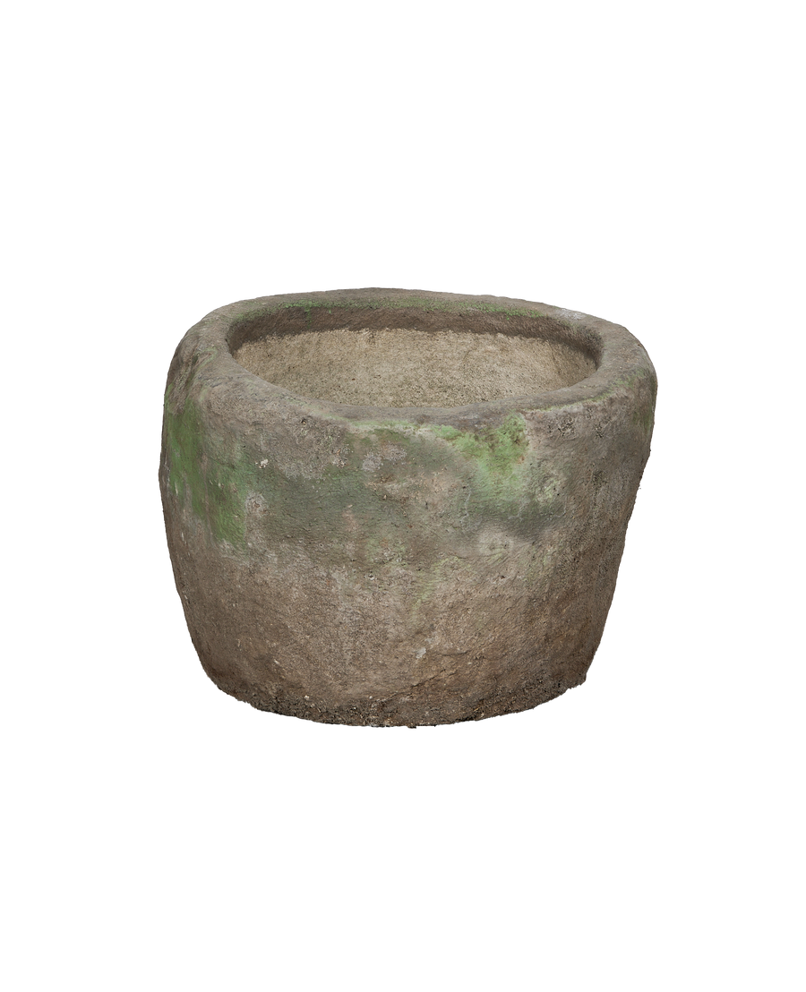 Vintage Indonesian round limestone trough, showing internal textured surface and aged green patination, side view.