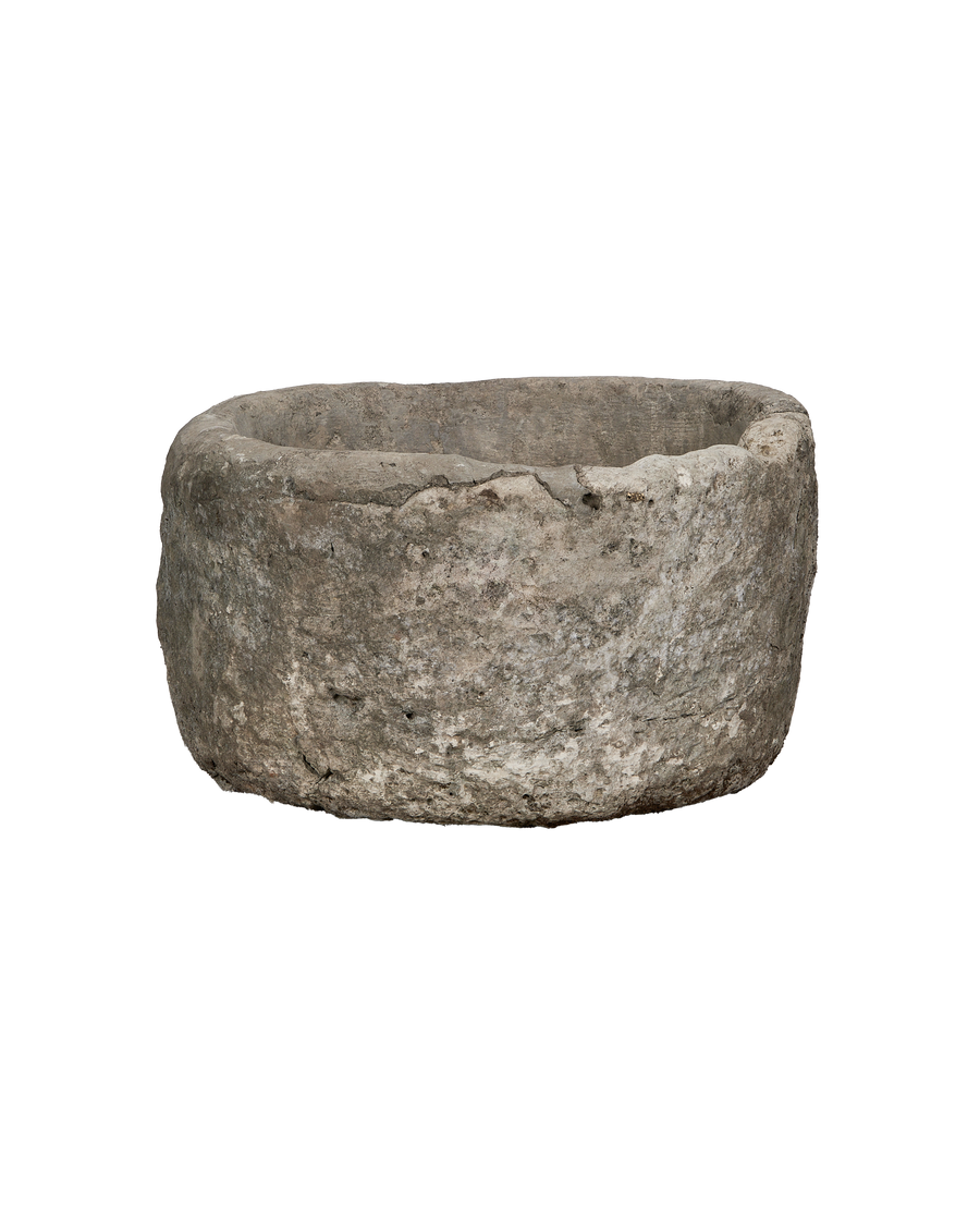 Vintage round Indonesian limestone trough, showing a slightly angled profile and weathered texture.