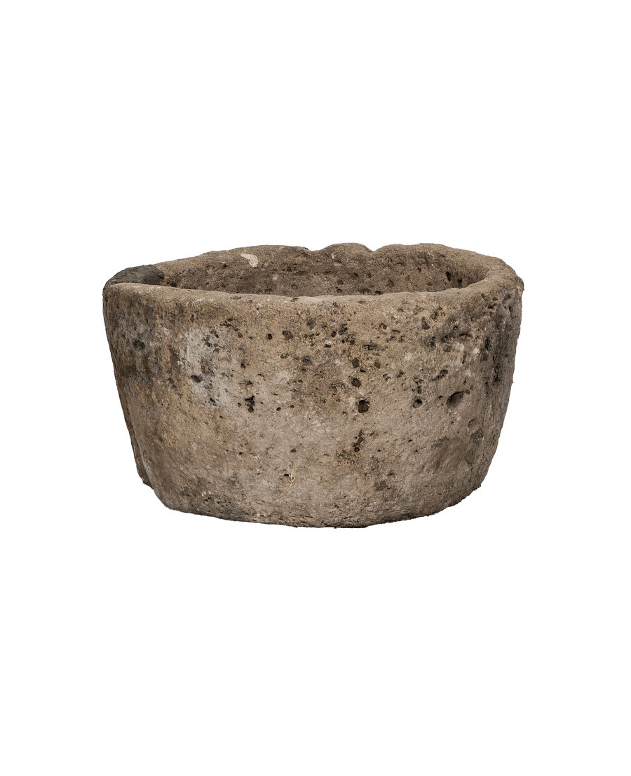 Vintage Indonesian round limestone trough, close-up of textured surface and rough rim.