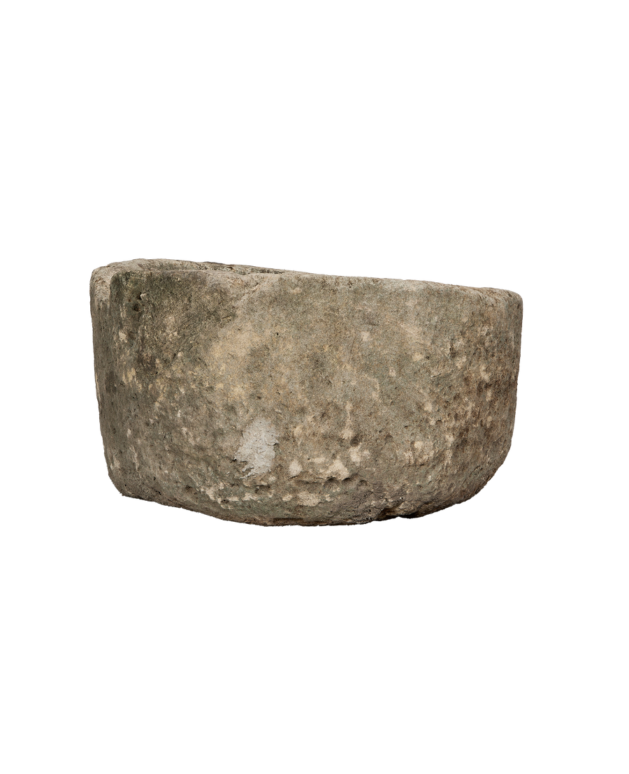 Bottom side/edge view of a vintage round limestone trough from Indonesia, showing texture.