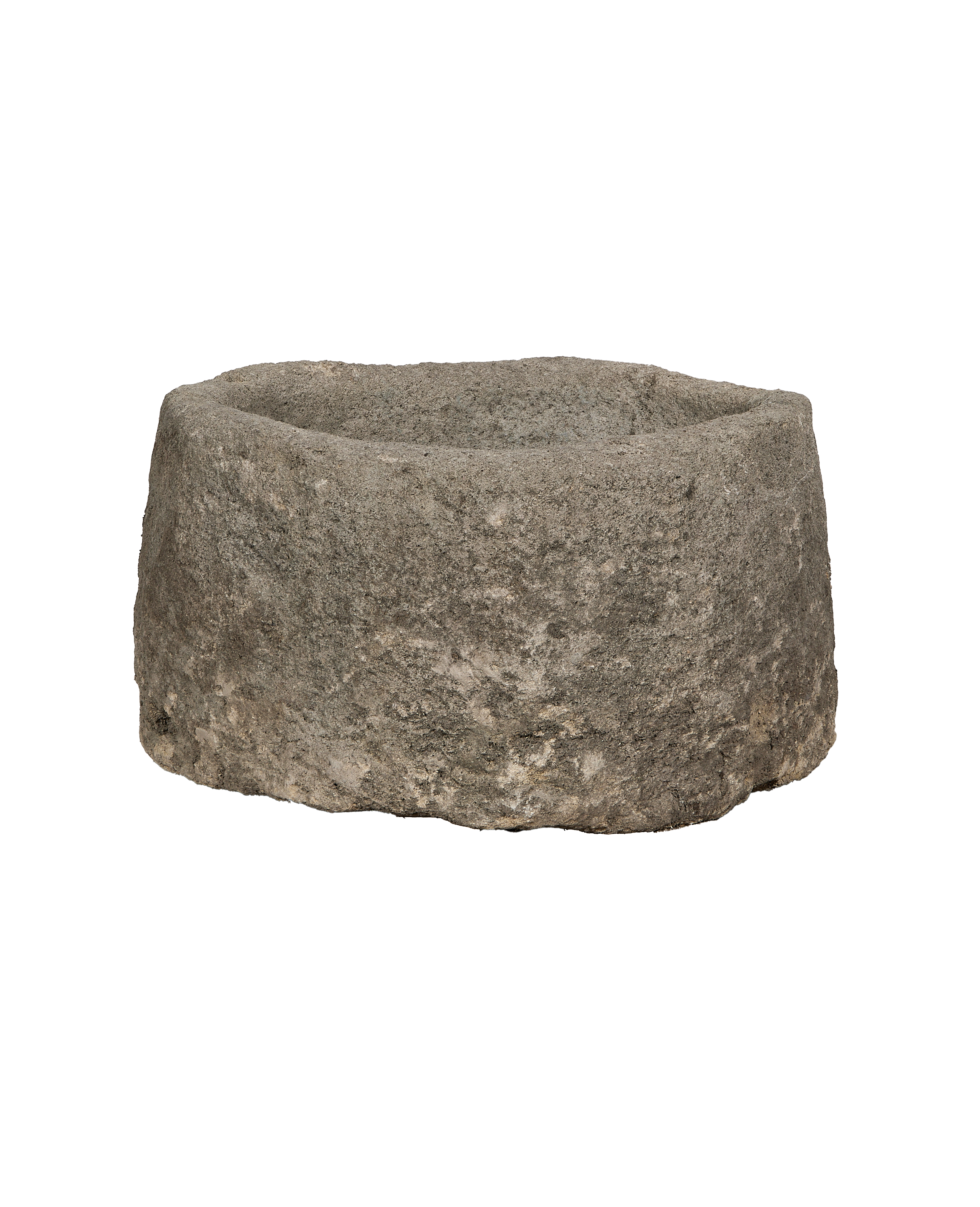 Vintage Indonesian round limestone trough, showing rugged texture and weathered gray stone from a side angle.