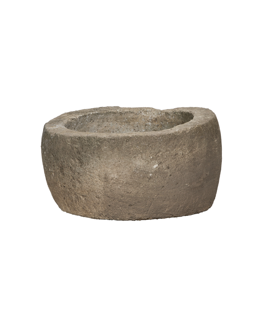 Vintage Indonesian limestone trough, showing rough textured exterior and gently sloped interior.