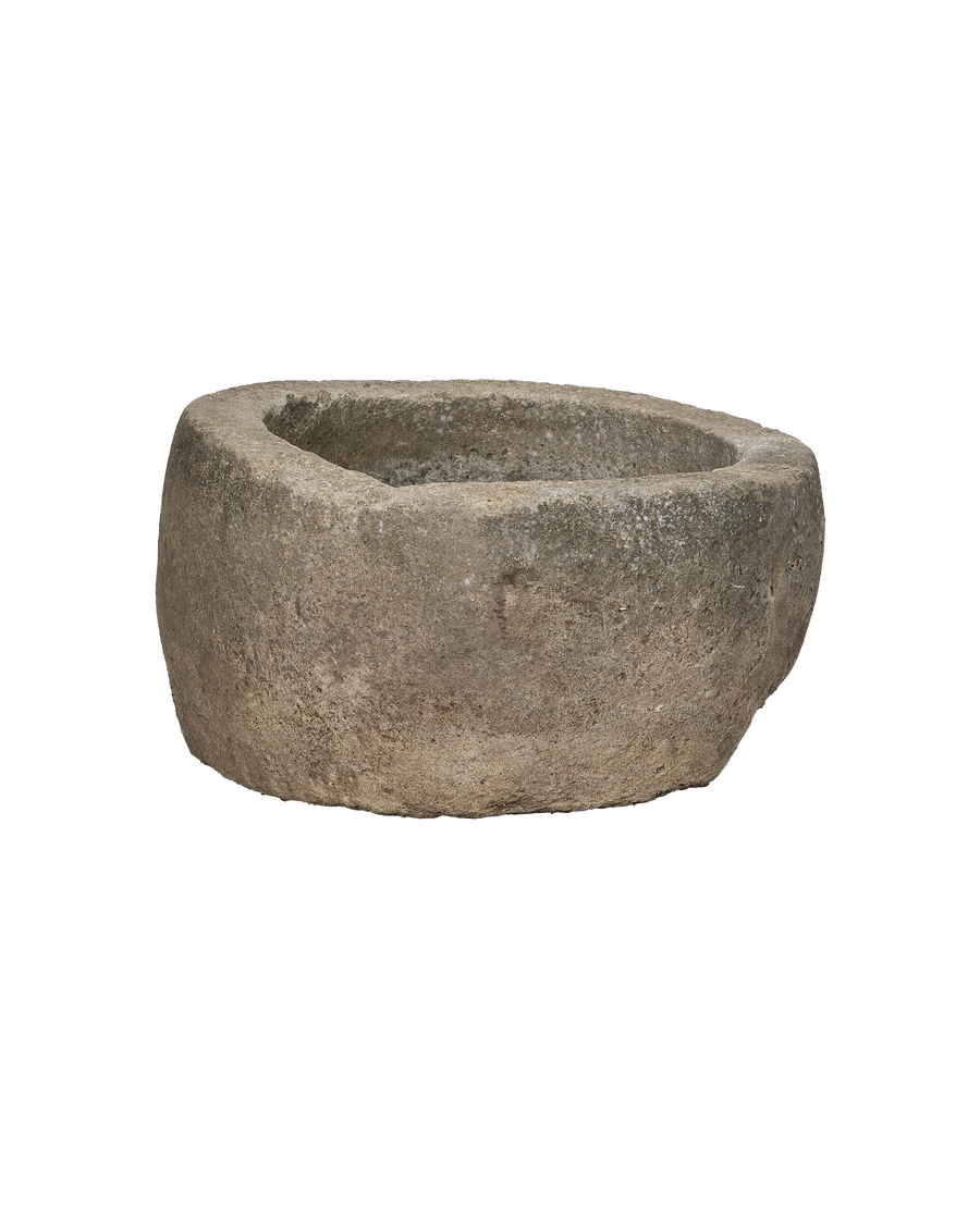 Vintage Indonesian round limestone trough, close-up of rough textured surface and weathered rim.