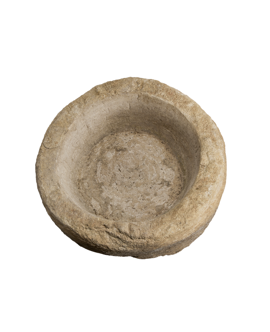 Vintage round limestone trough, top-down view showing deep interior well and rough outer texture.