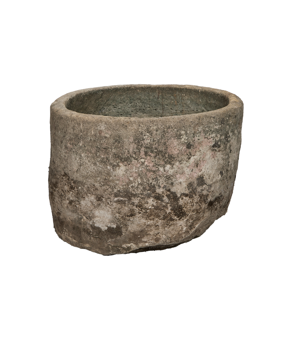 Vintage round limestone trough, rich moss and varied patina, exterior view.