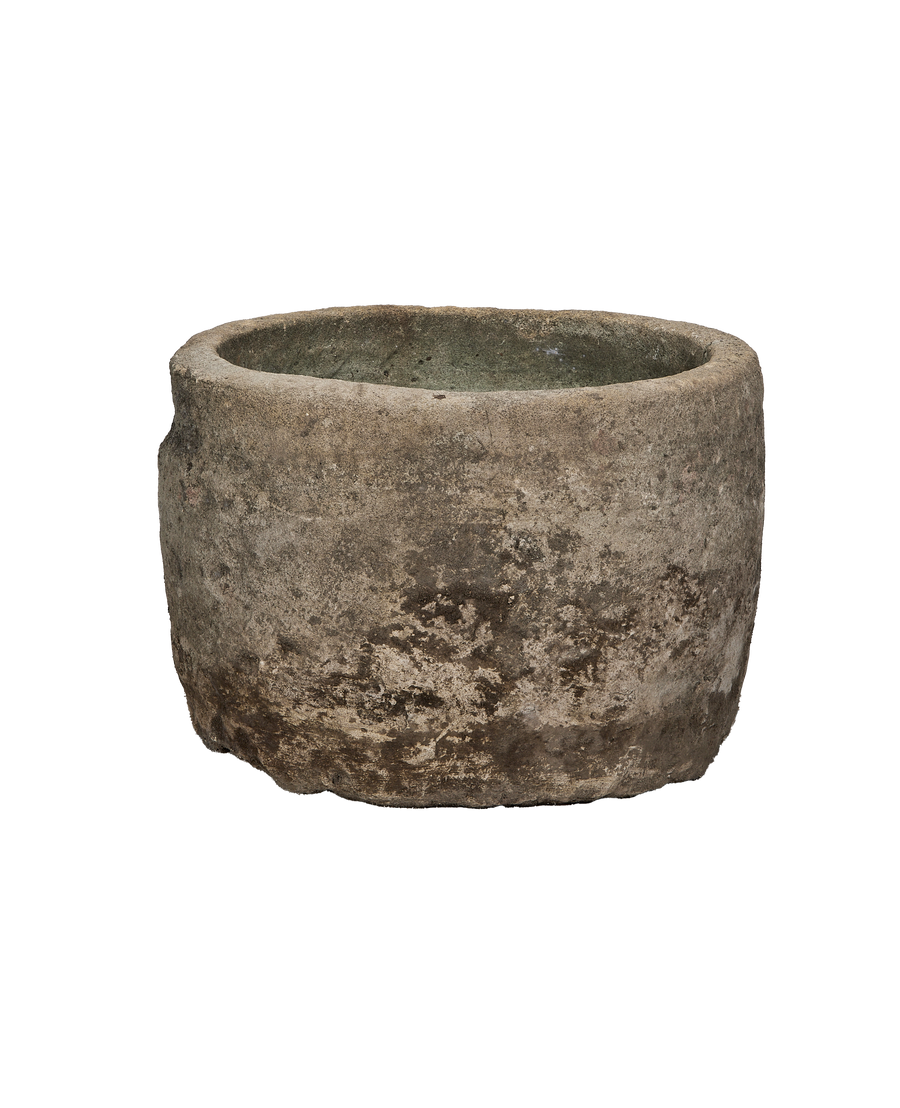 Vintage Indonesian round limestone trough, showing weathered texture and natural gray-green interior.