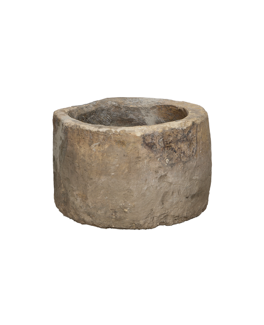 Vintage Indonesian round limestone trough, rich exterior texture, close-up.
