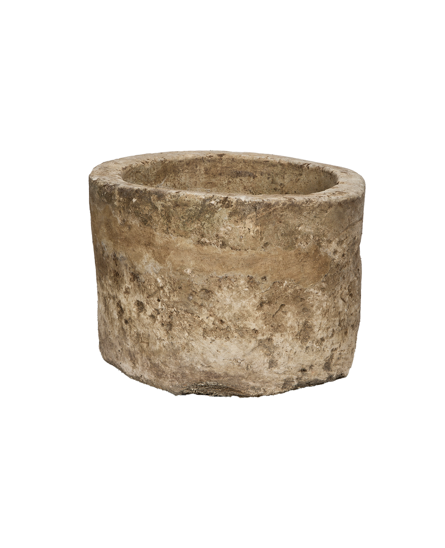 Vintage Indonesian round limestone trough, showing weathered texture from a unique low angle.