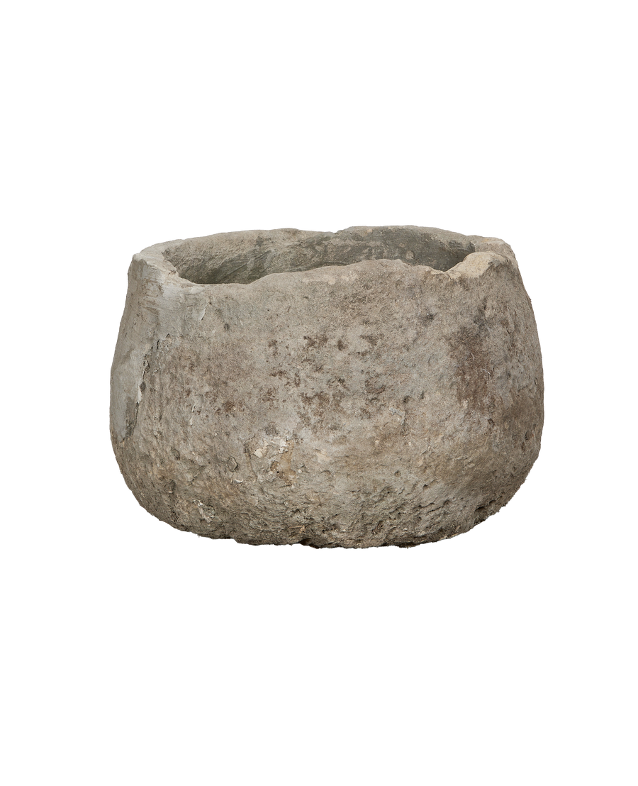 Vintage round limestone trough, close-up texture, showing rough weathered surface detail.