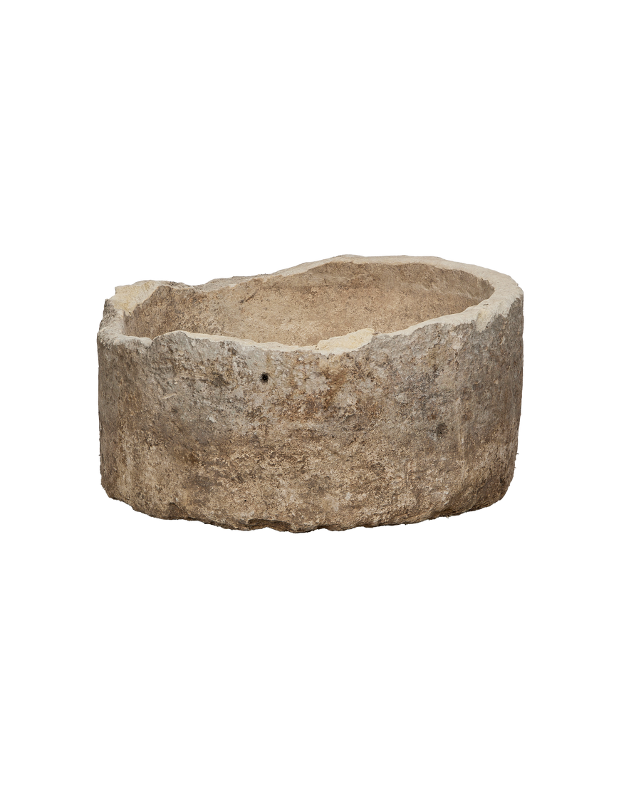 Vintage round Indonesian limestone trough, showing rugged texture and a small drill hole.