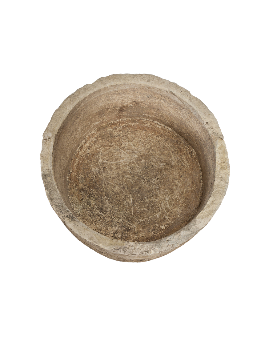 Vintage round limestone trough, top view showing weathered interior surface texture.