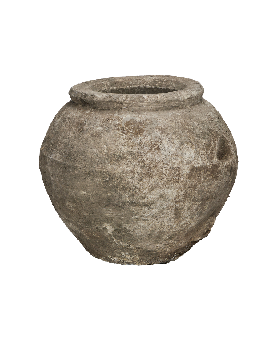 Vintage Indonesian limestone pot with rough texture and weathered surface detail from side view.
