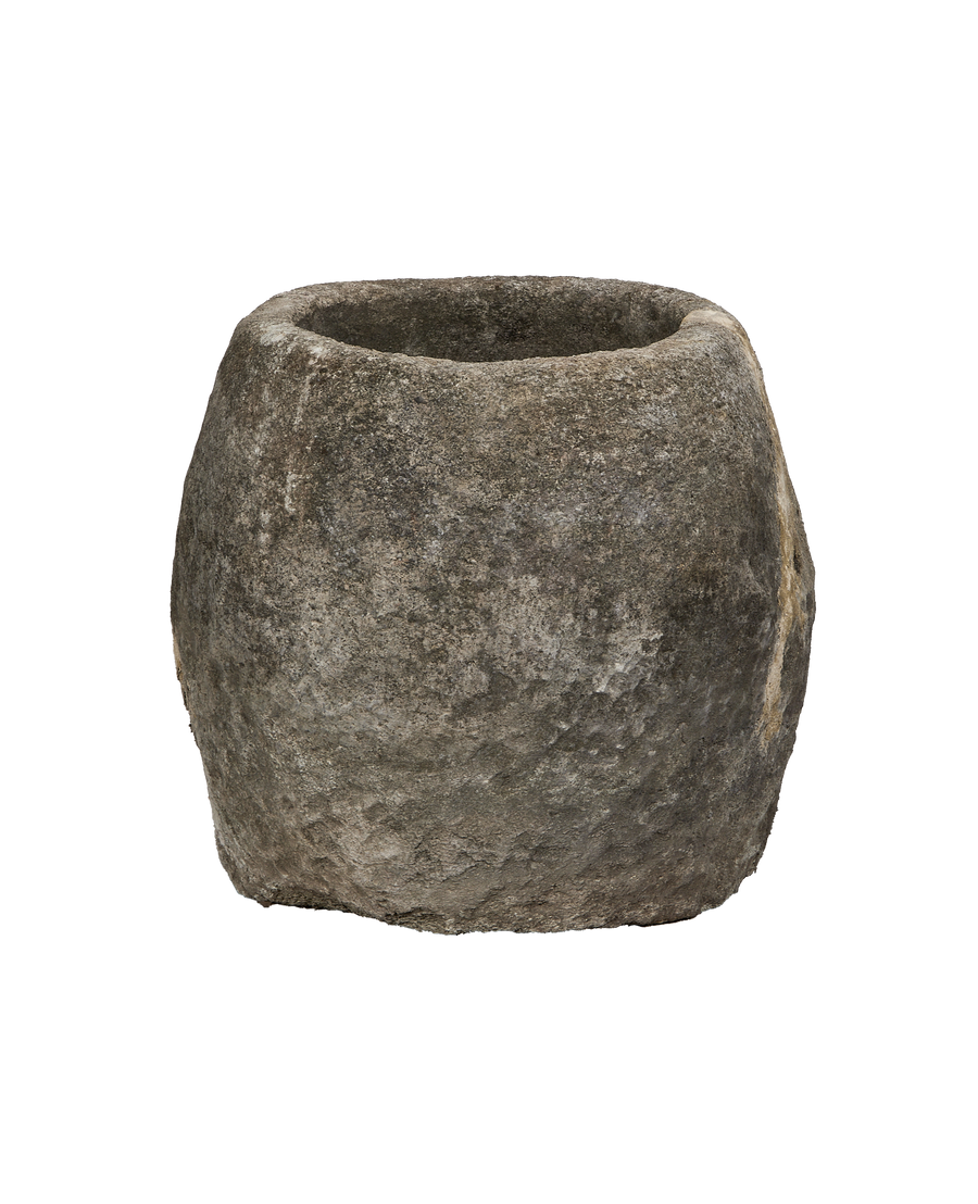 Vintage Indonesian round limestone trough, showing its rough, weathered texture and tapered top.