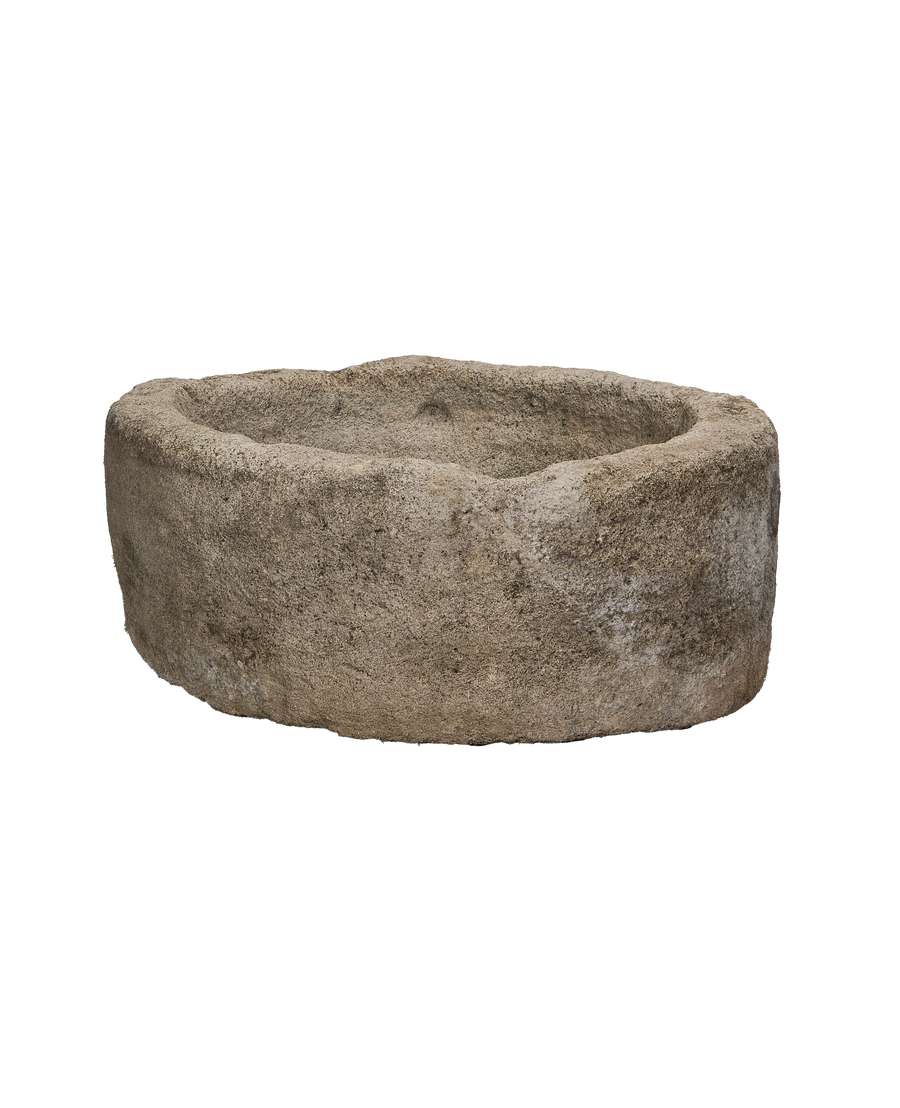 Vintage round Indonesian limestone trough, showing internal and external textural details from a lower angle.