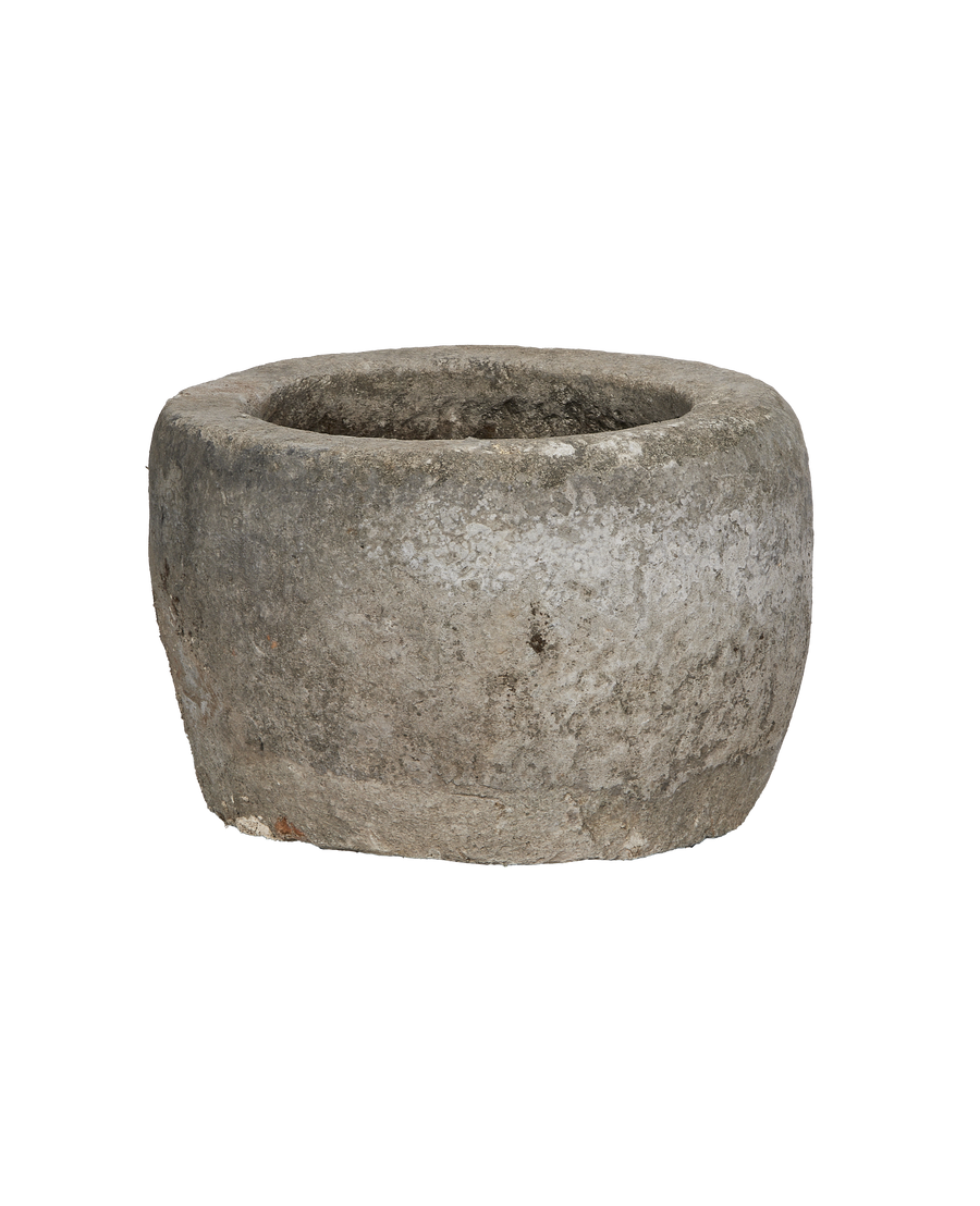 Vintage Indonesian round limestone trough, showing weathered texture and interior basin detail from side.