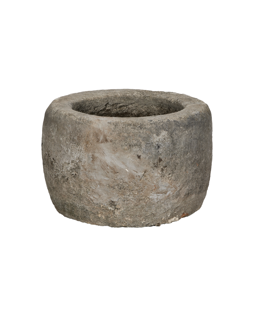 Vintage Indonesian round limestone trough, showing weathered texture from an elevated angle.