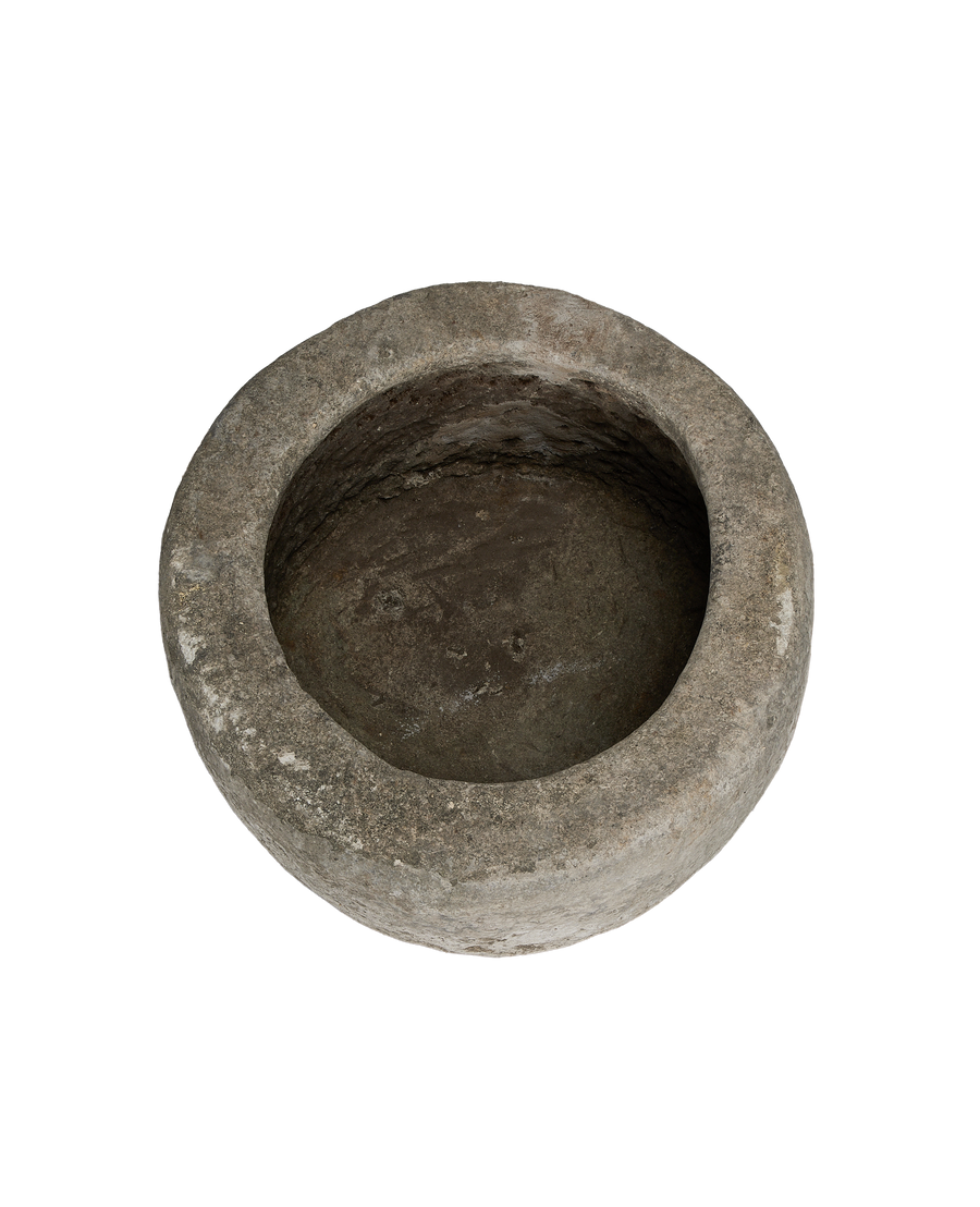 Vintage round limestone trough, top view showing aged interior texture and rough rim.