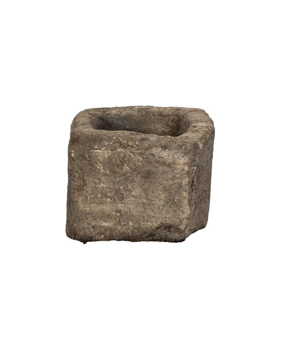 Vintage Indonesian limestone trough, dark gray and textured, showing rough sides and interior.