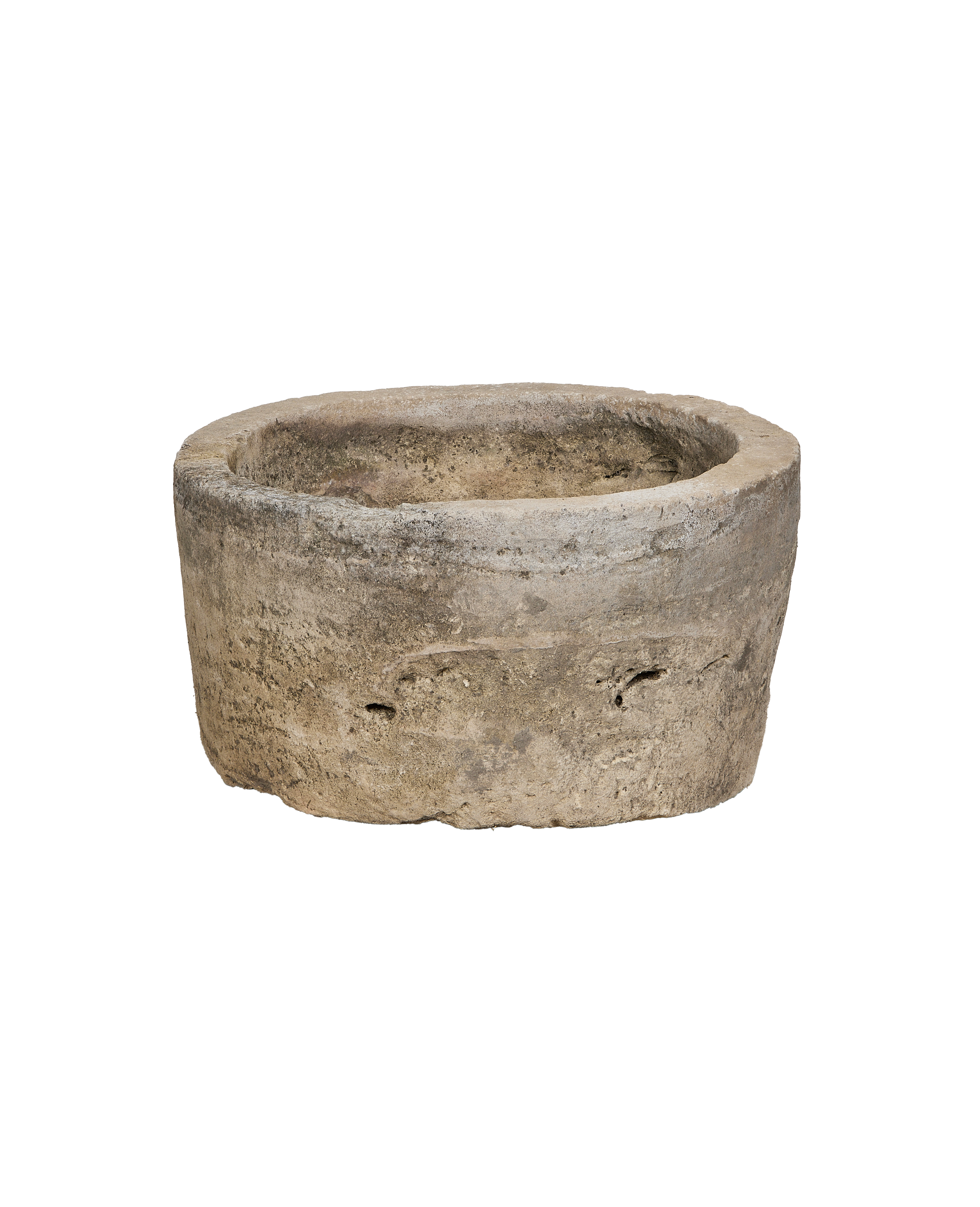 Vintage Indonesian limestone trough, partially visible, showcasing weathered texture and circular shape from a low angle.