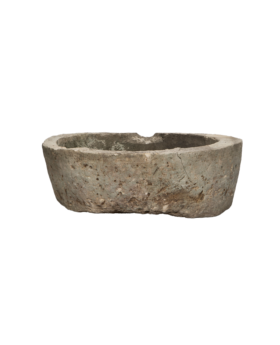 Vintage round Indonesian limestone trough, showing a shallow chip on the weathered rim.