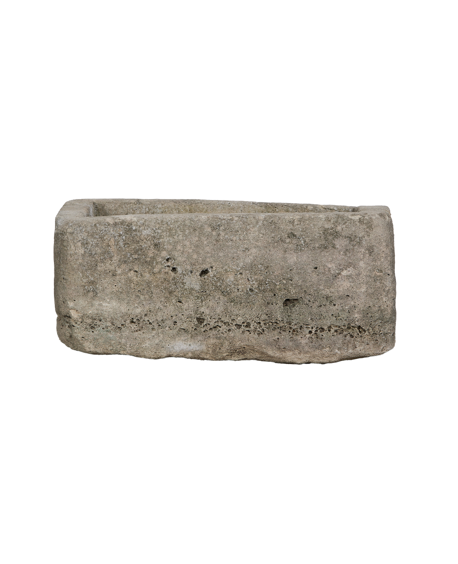 Vintage rectangular limestone trough, side angle, showing the weathered texture and rough-hewn stone.
