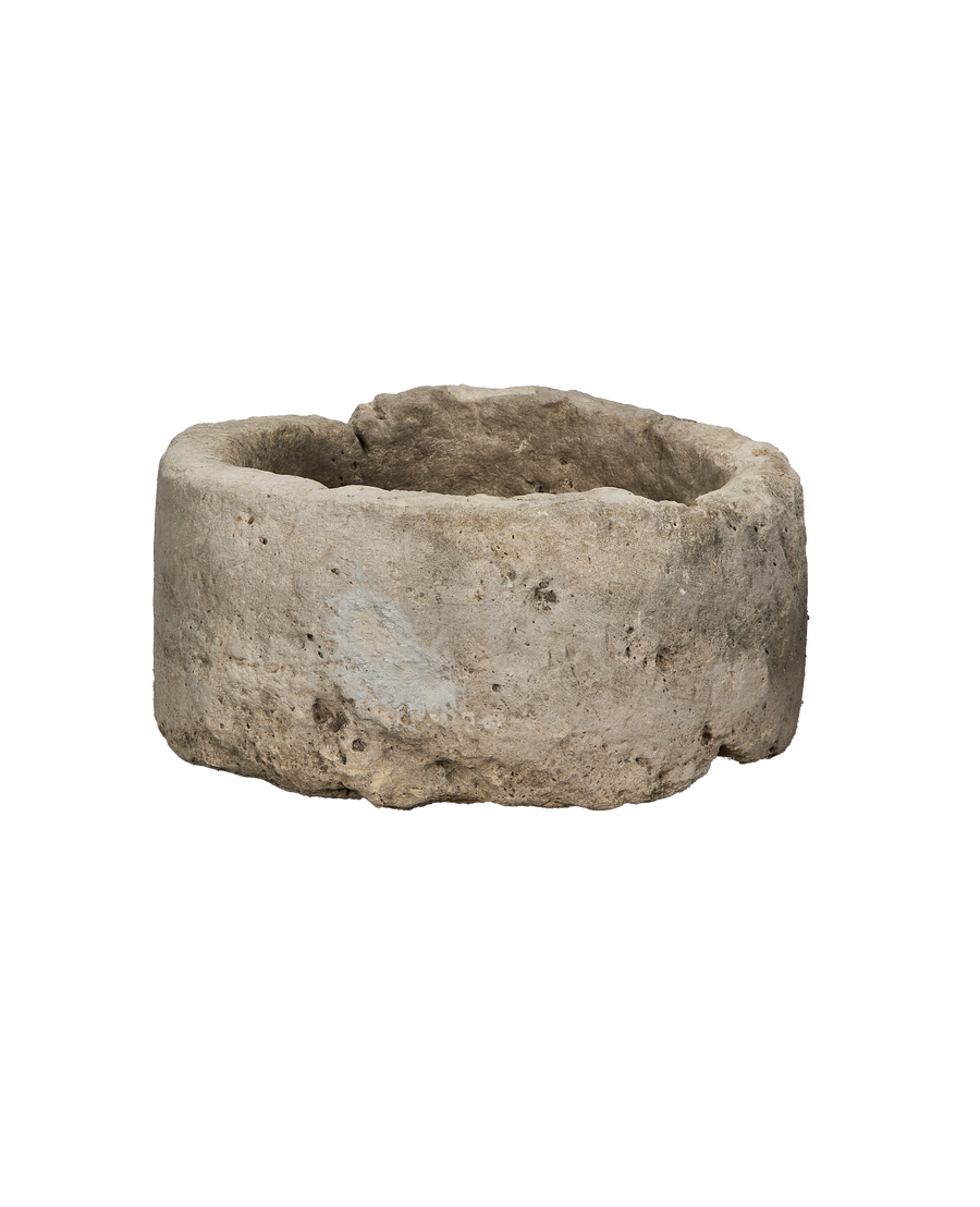 Vintage round limestone trough, side angle view, rustic texture, weathered condition.