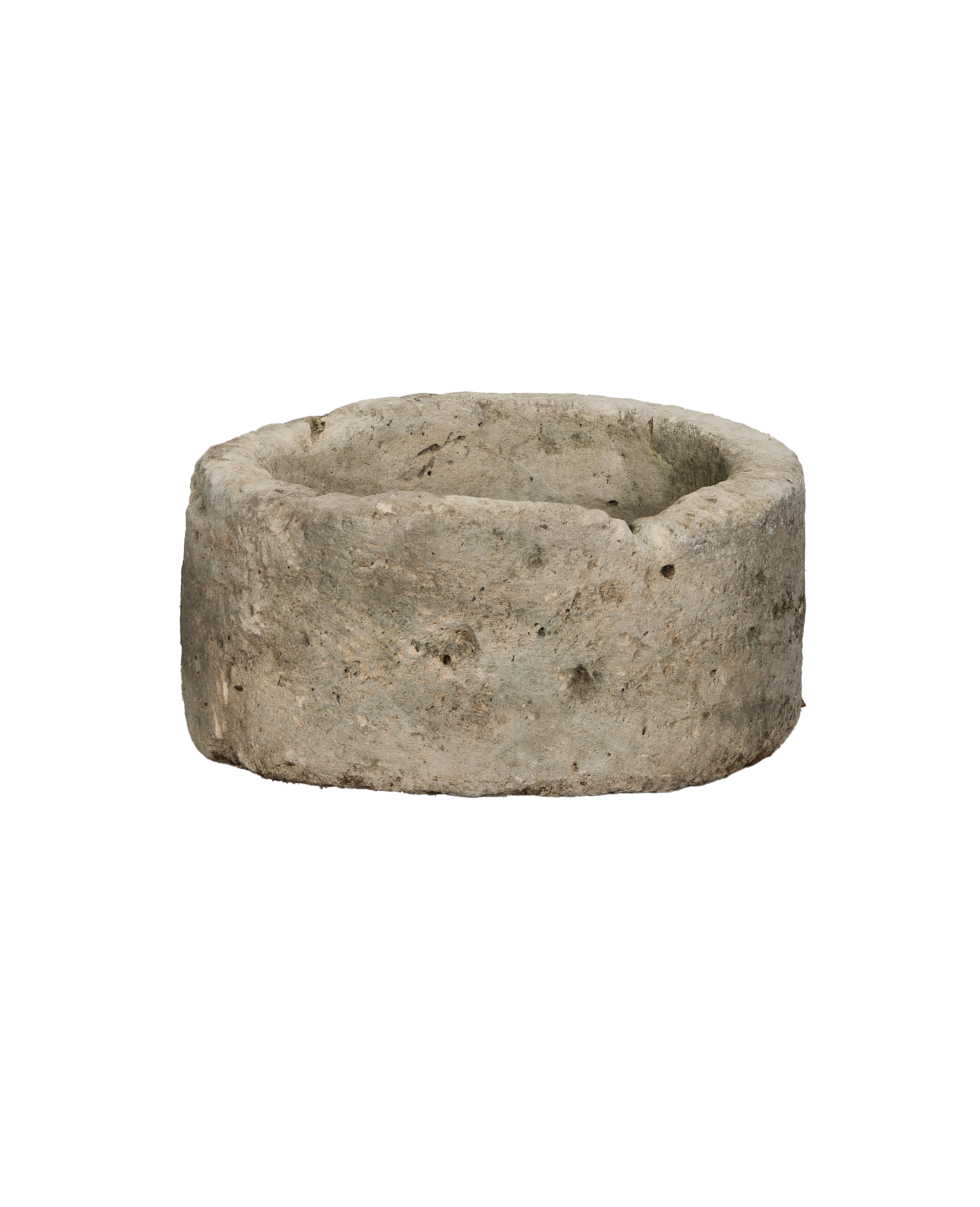 Vintage round Indonesian limestone trough showing weathered texture and natural imperfections, side-angle view.