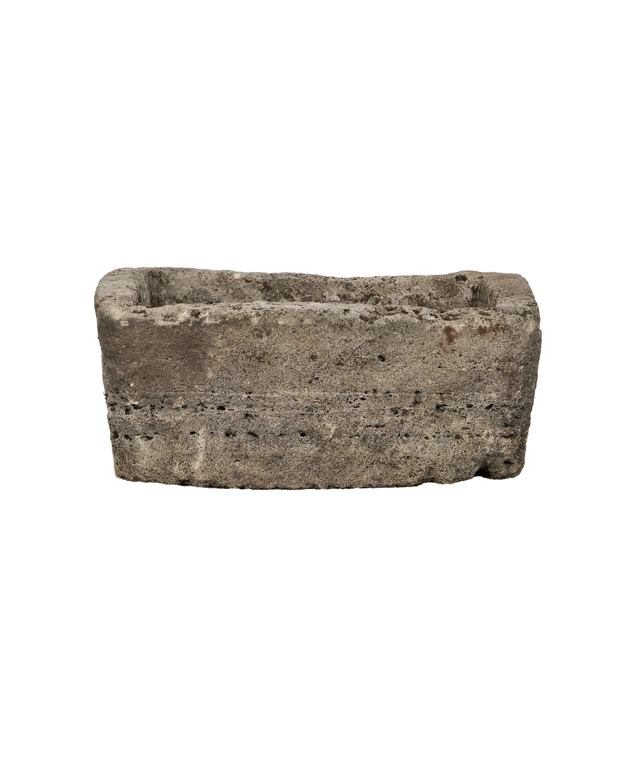 Vintage rectangular limestone trough, showing weathered texture and small holes along the unpolished body.