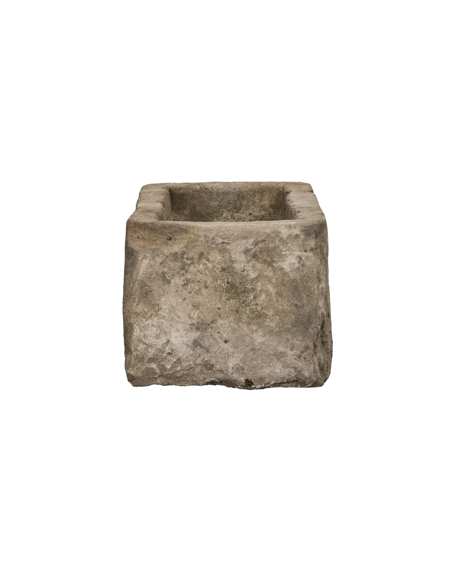 Vintage Indonesian limestone trough, close-up of rough textured stone surface and worn edges.