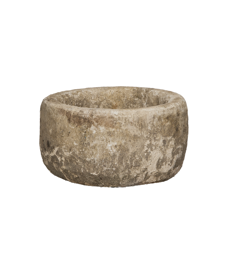 Vintage Indonesian round limestone trough, showing weathered texture from a slightly elevated side view.