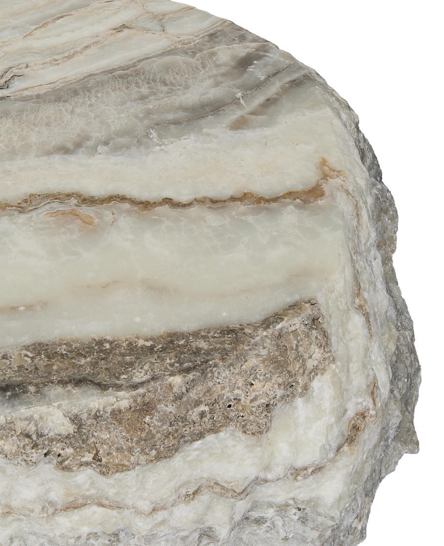 Close-up of the onyx coffee table's raw, variegated slab edge showcasing natural rough texture.