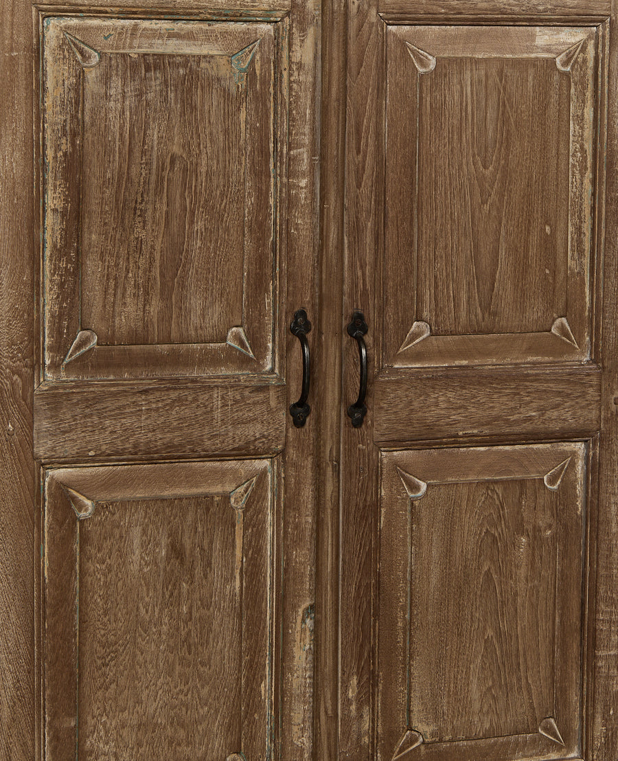 Detailed view of Indian vintage oak cabinet doors with distressed natural finish and ornate black iron handles.