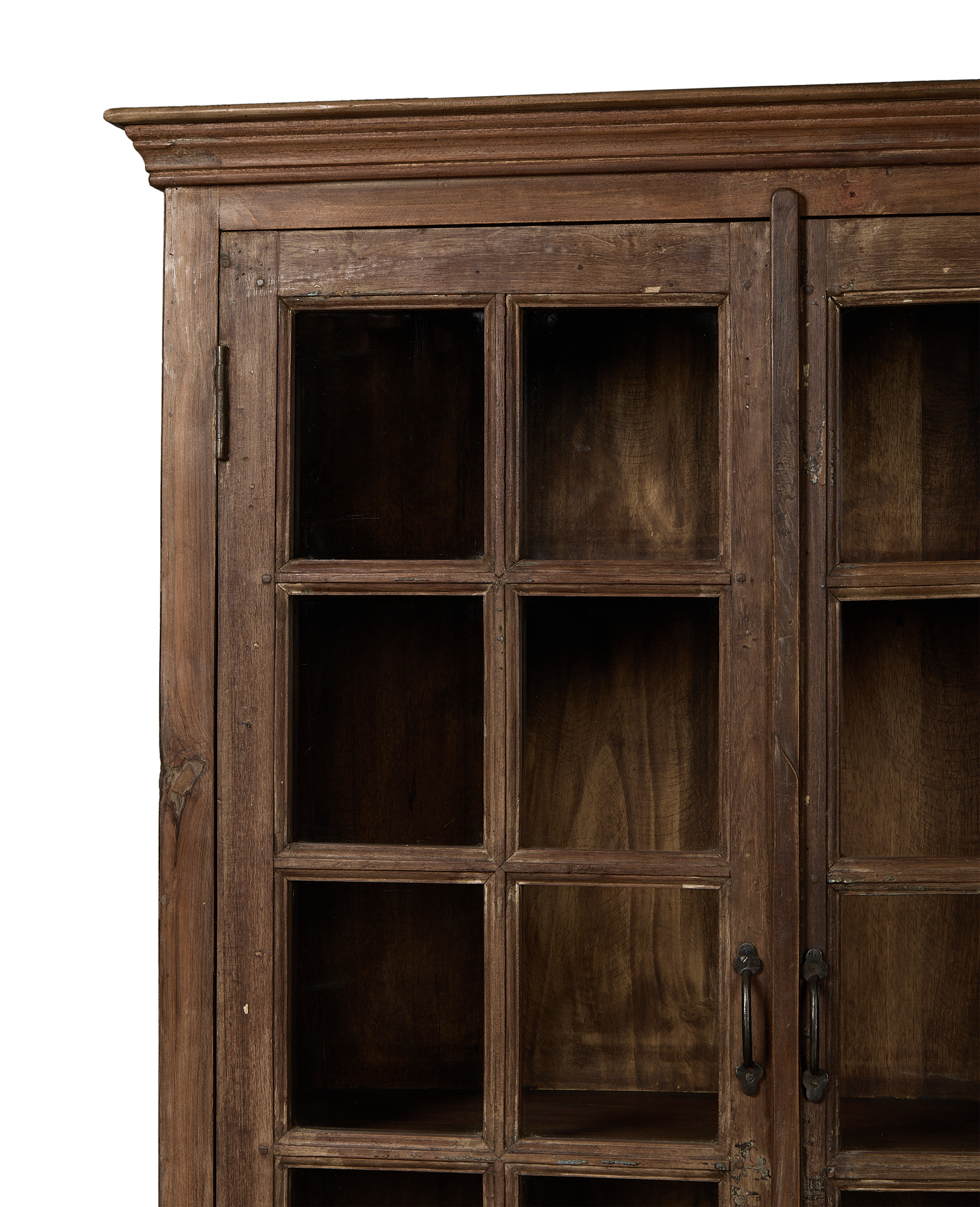 Left-side detail of vintage Indian oak wood cabinet, showcasing paneled glass doors and rustic hinge.