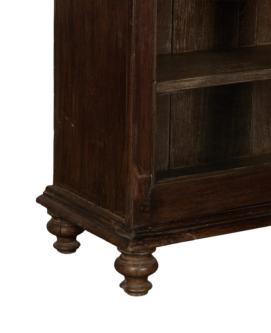 Vintage Indian oak cabinet bottom showing ornate turned feet and aged wood grain.