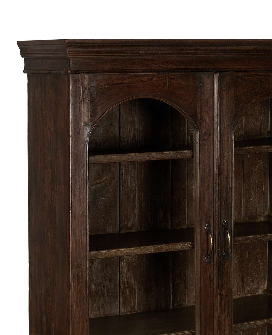 Vintage dark oak wood cabinet with glass door. Close-up: arched top shelf.