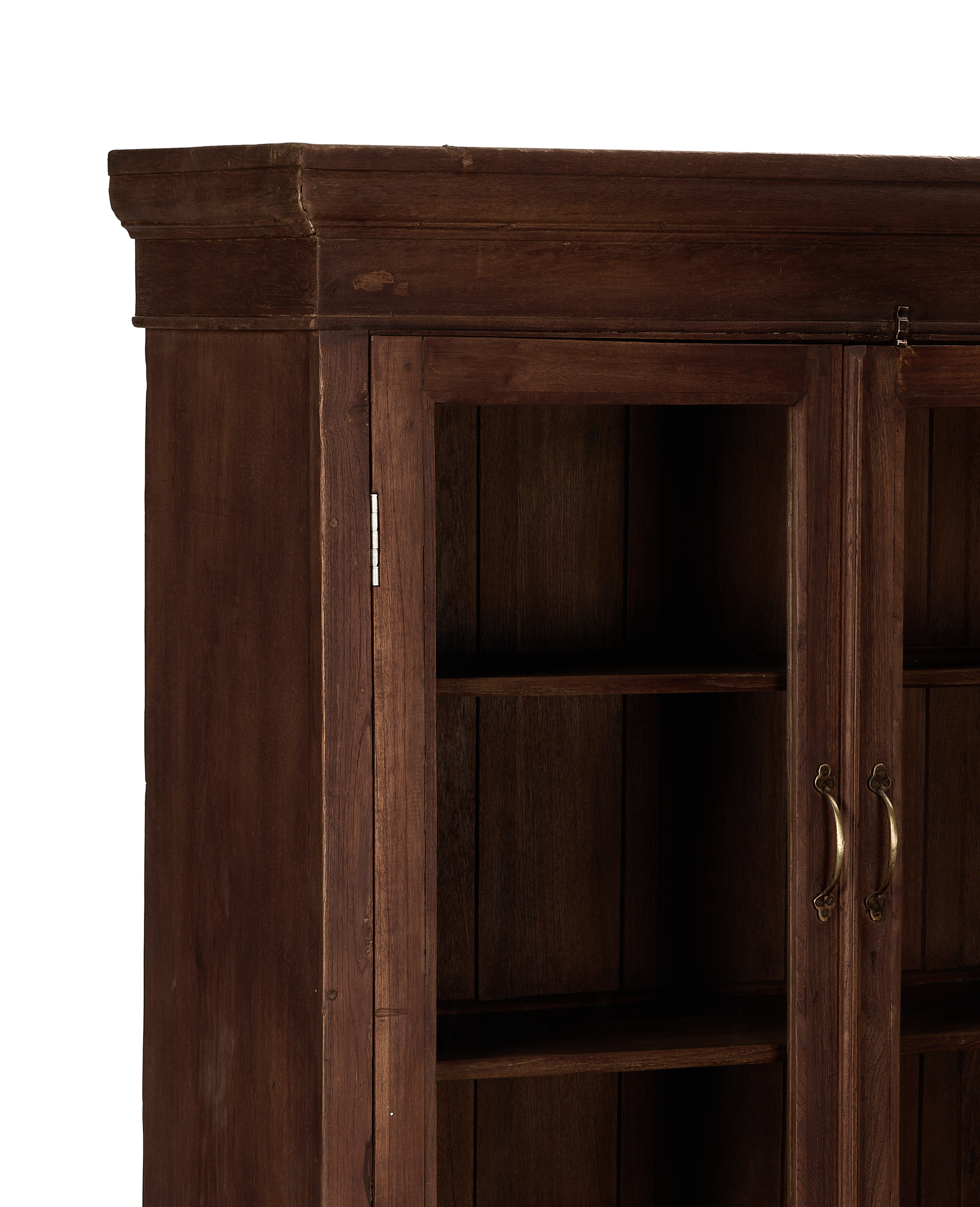 Close-up of the vintage Indian oak cabinet's top right corner, showing brass handles and interior shelves.