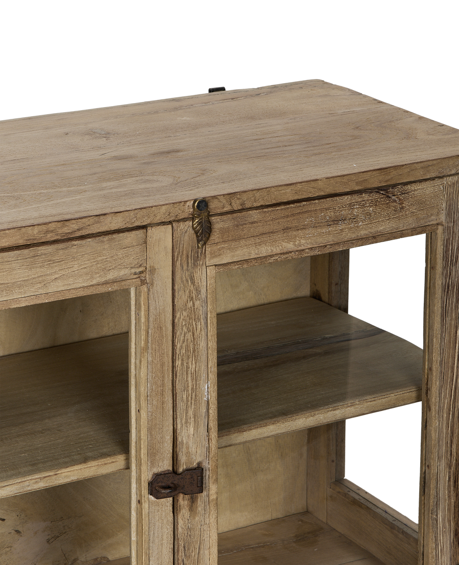Close-up of vintage Indian bleached oak cabinet's top, rustic leaf latch, and glass shelves.