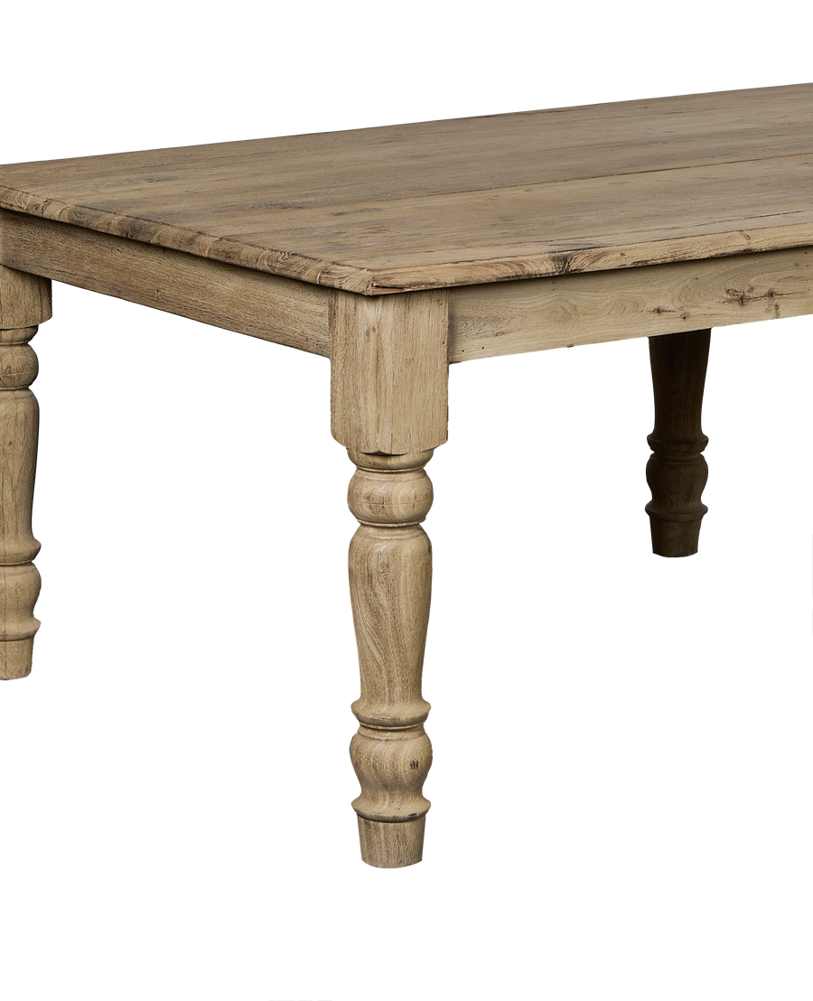 Bleached oak vintage Indian dining table corner view, showing distressed wood grain and carved leg detail.