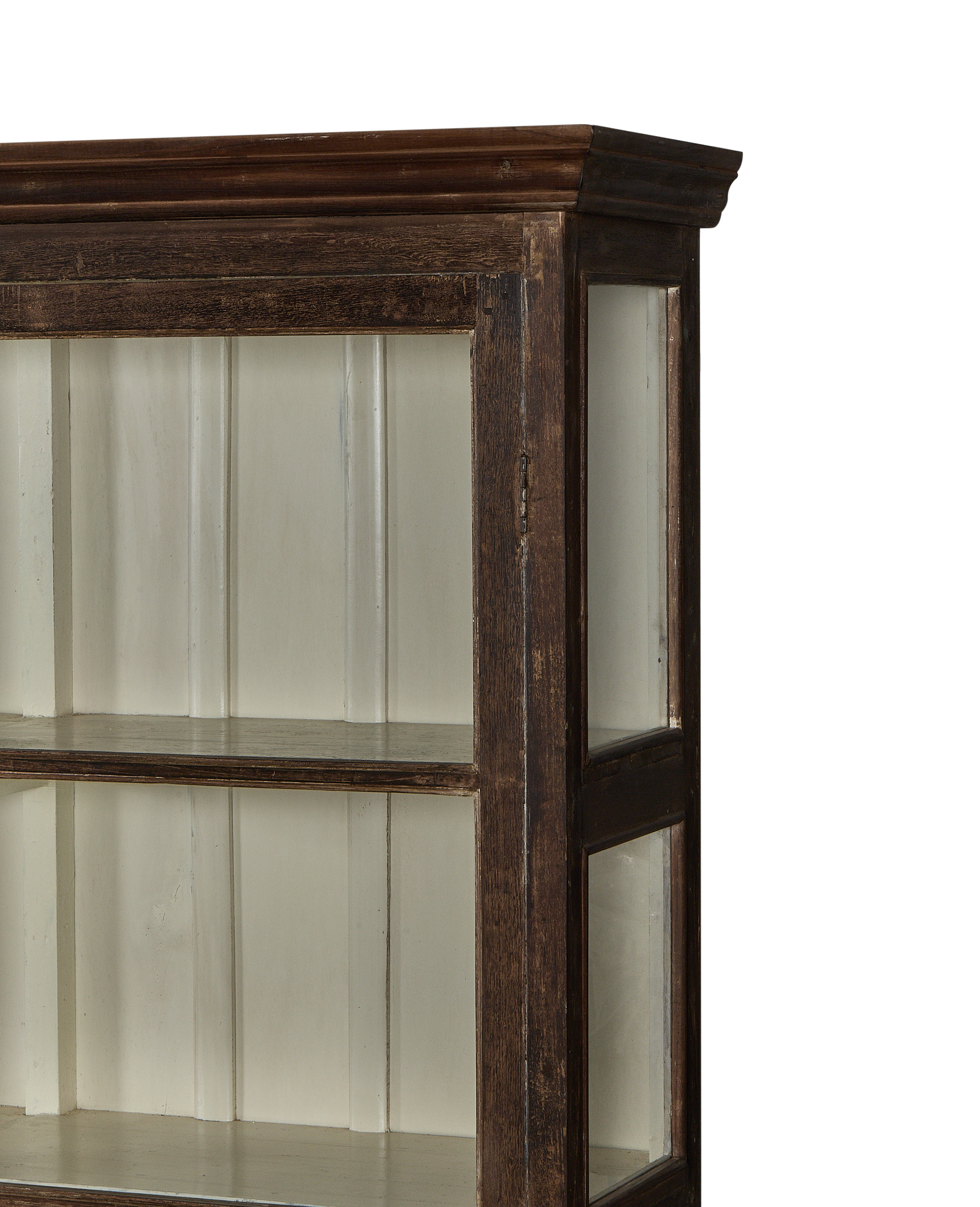 Side view of a vintage Indian oak display cabinet with glass doors and a white painted interior.