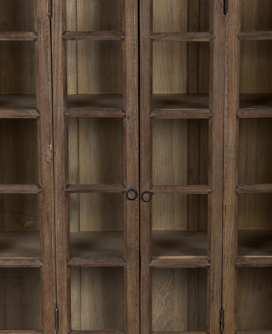Close-up of vintage Indian bleached oak cabinet with glass panel doors and handles.